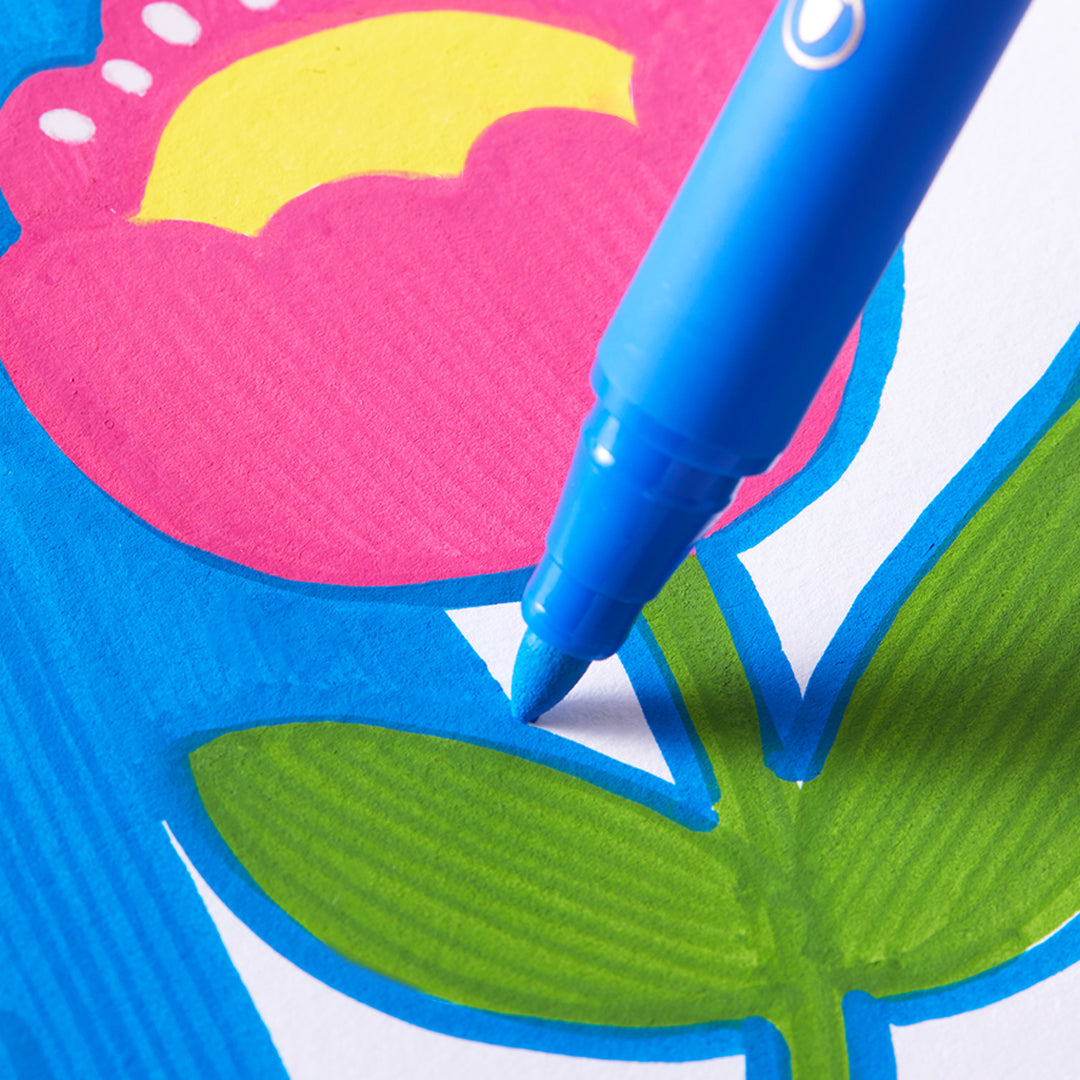 Blue acrylic marker with round nib drawing on paper, ideal for beginners and versatile on multiple surfaces.