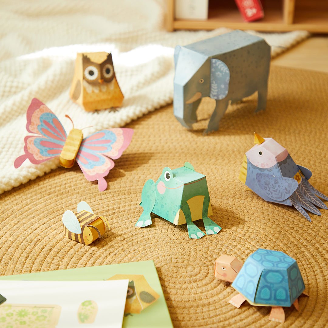 Assorted 3D origami paper animals on woven mat showcasing creative kids&