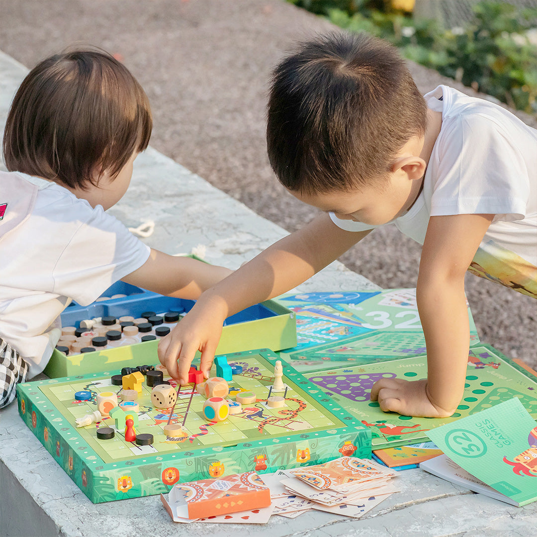 Two children engaged in playing 32 in 1 Classic Games board game with various pieces and cards on display